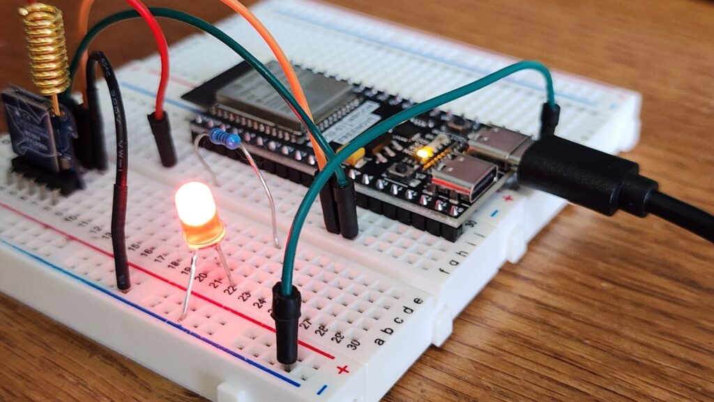 Detailed view of a breadboard with LED and microcontroller, showcasing DIY electronics.