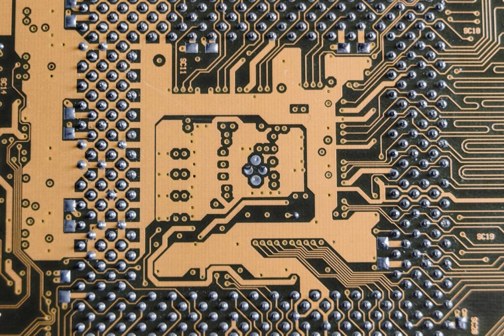 Detailed view of a circuit board showcasing intricate patterns and metallic connections.